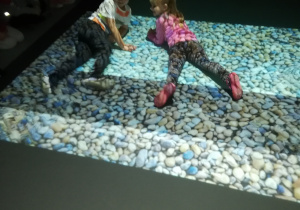 Chłopiec z dziewczynką leża na kamieniach w wodzie